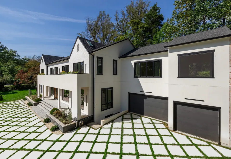 Side of the house with garage doors and grass-joint pavers